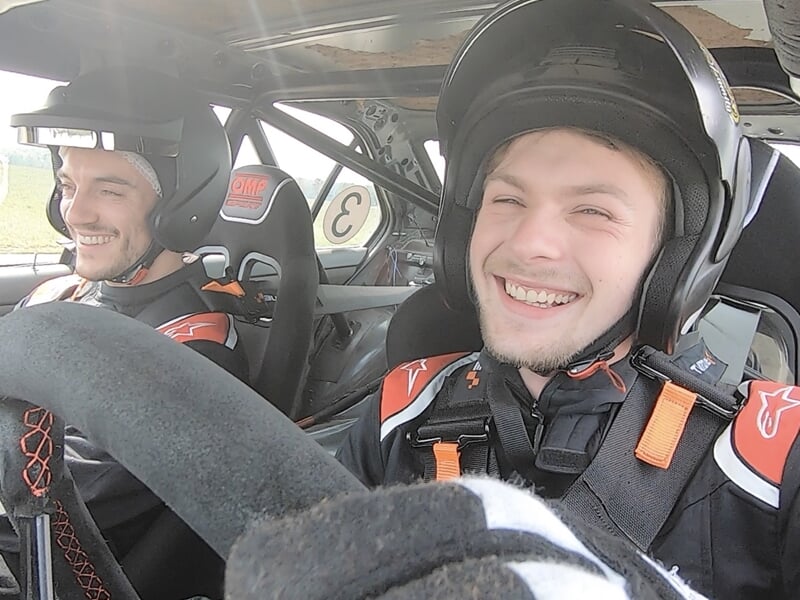 Pilote et passager au volant d'une voiture sur circuit