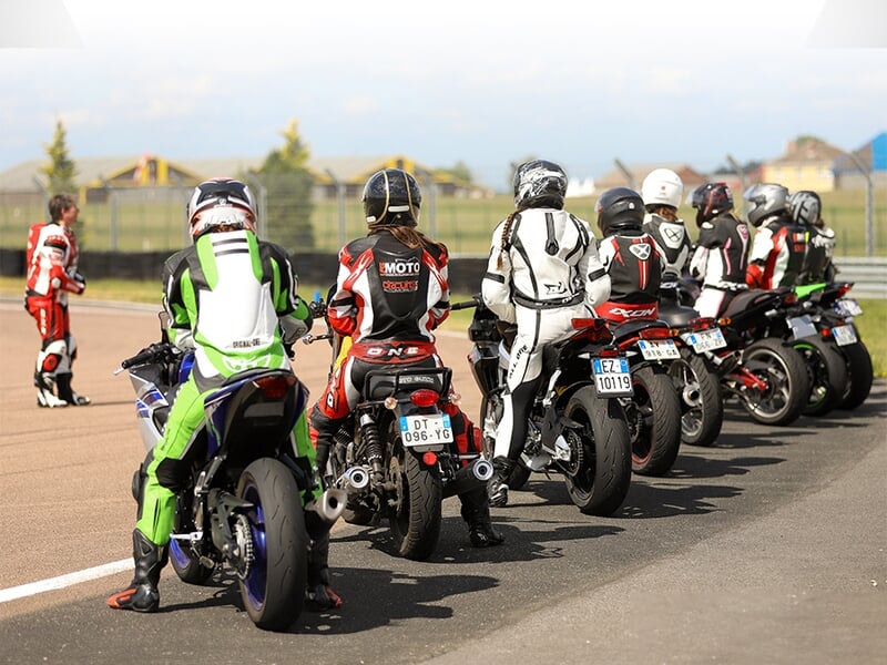 Groupe de pilote de moto alignés sur circuit