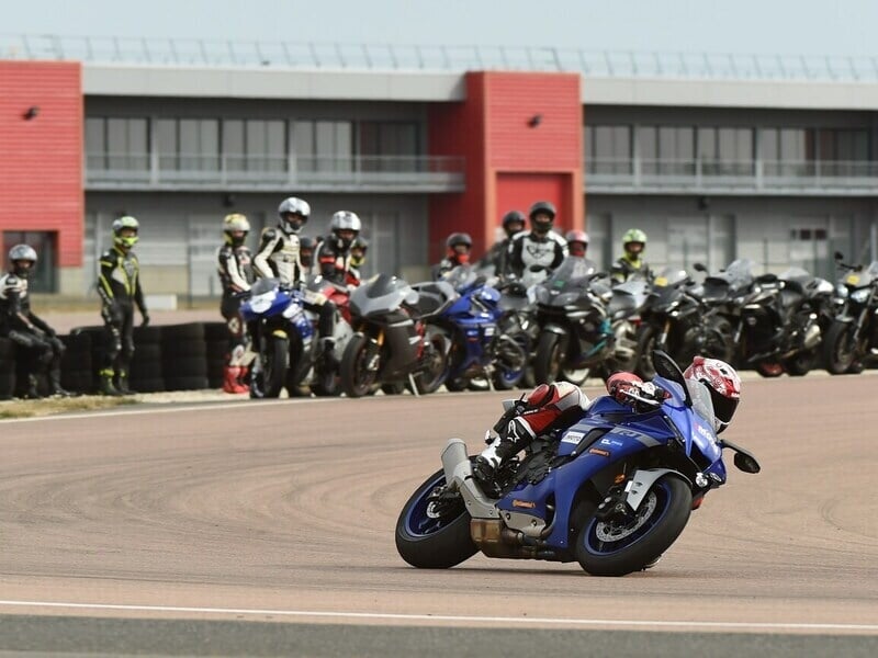 Groupe de motard observant une personne pilotant sur circuit