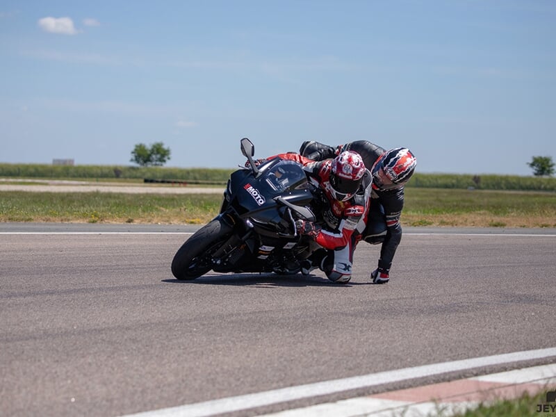 Moto sportive en pleine accélération sur une piste de course, inclinaison forte des pilotes.
