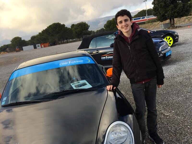 Un ado pose devant la voiture d'un centre de pilotage réservé aux mineurs dans les environs de Toulon.