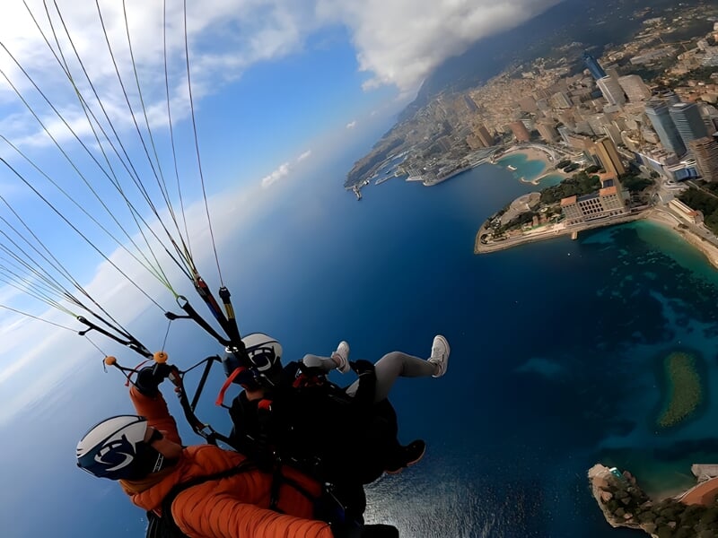 deux personnes survolent la côte d'azur en parapente