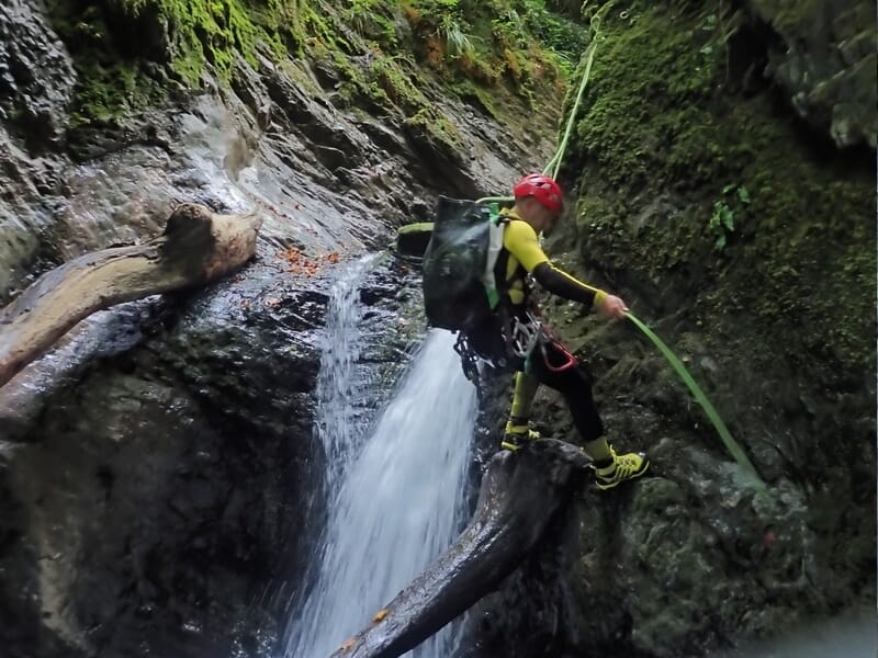 homme pratiquant la descente en rappel dans le canyon de Yèse