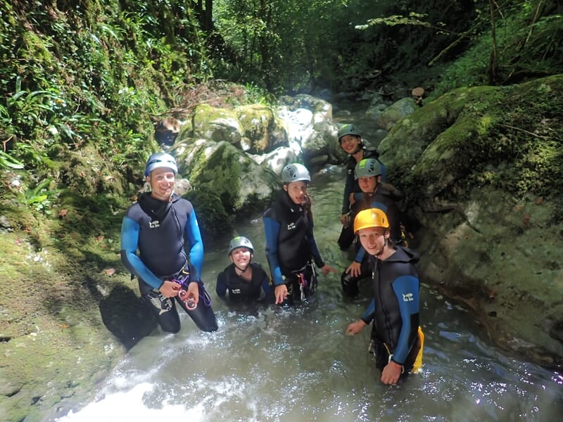 Groupe pratiquant le canyoning prenant la pose dans une rivière