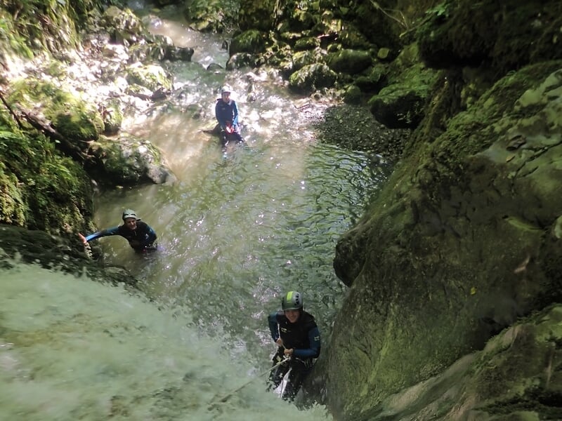 Groupe pratiquant le canyoning près d'une cascade