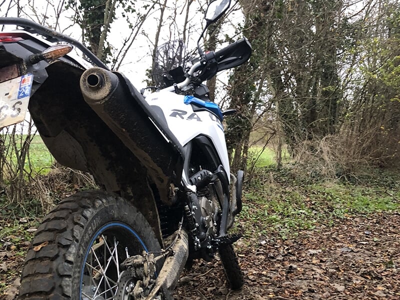Une moto de cross vue de derrière avec un gros plan sur la roue arrière et le pot d'échappement