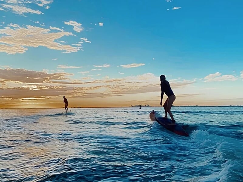 deux surfeurs faisant une rendonnée de surf électrique sur l'océan