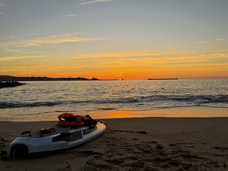 Planche de surf électrique posée sur la plage face àl'océan au crépuscule