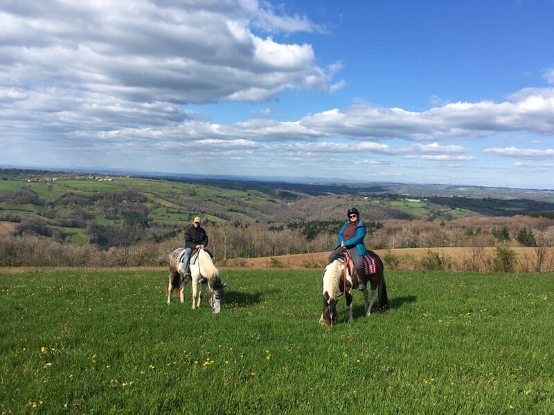 Deux personnes en balade à cheval à la campagne