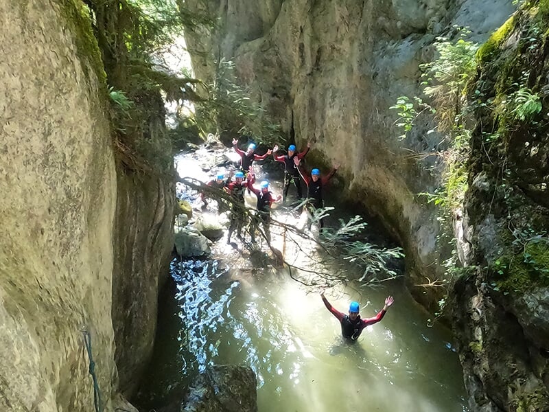 Des canyoneurs posent pour la photo les bras levés au cours d'une randonnée aquatique