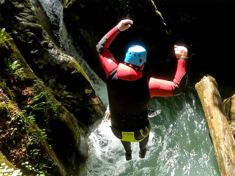 Un canyoneur fait un saut dans un torrent durant une descente de canyoning