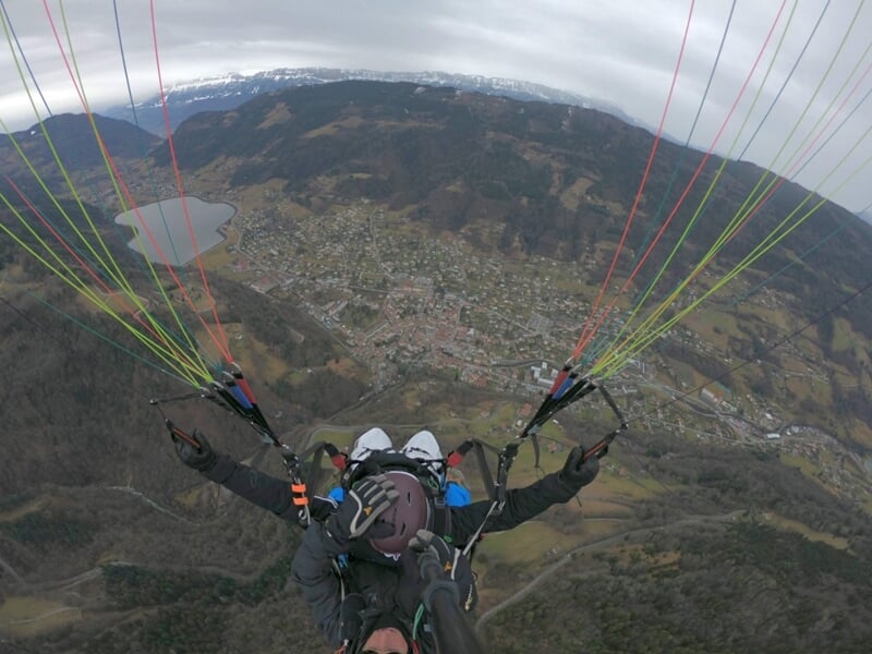 Deux personnes en parapente au dessus des montagnes