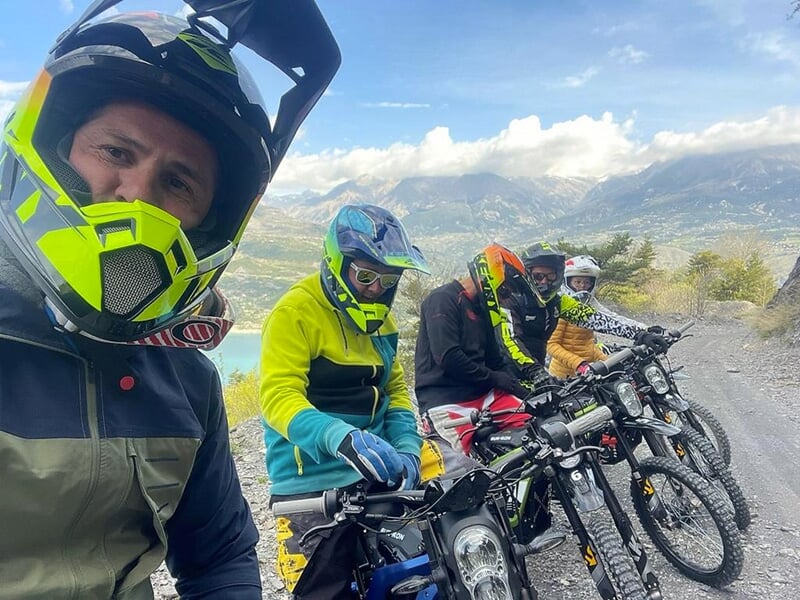 Un groupe de motards attend alignés sur leur deux-roues le départ de la randonné dans un paysage de montagne