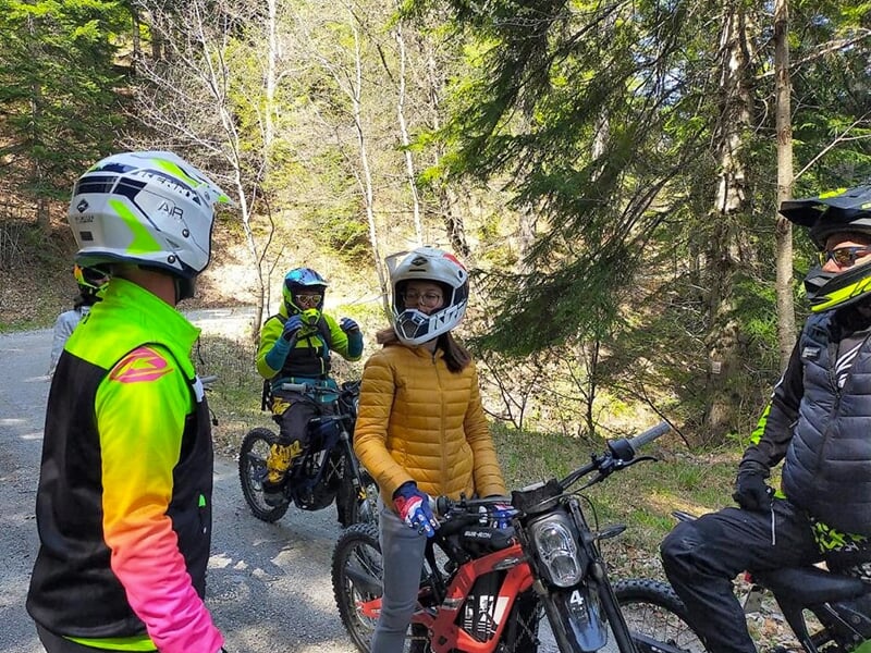 Des motars à l'arrêt discutent sur un chemin de terre en plein au milieu d'une forêt