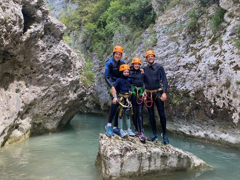 Groupes de randonneurs perchés sur un rocher au milieu d'une rivière au cours d'une descente de canyoning dans les gorges de l'Artuby