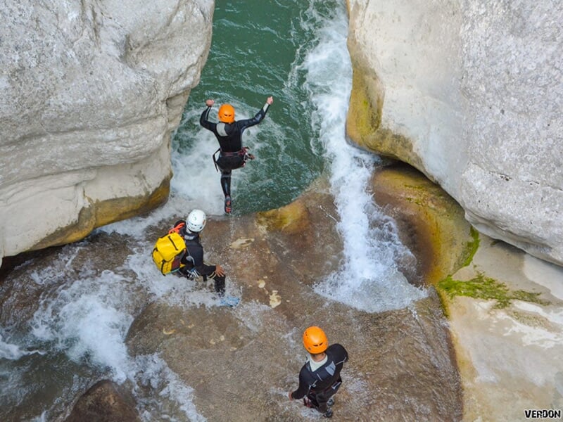 Un groupe de sportifs enchaînent les sauts au cours d'une sortie de randonnée aquatique