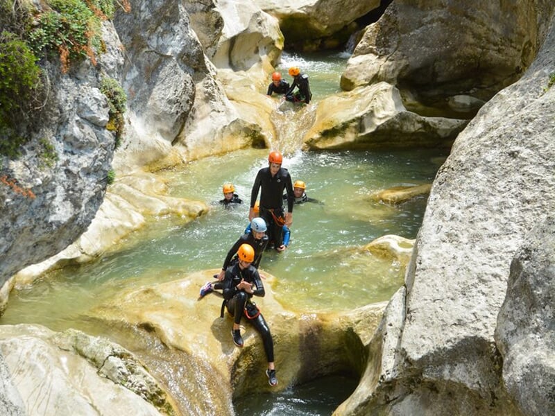 Groupe de randonneurs enchaînant les toboggans lors d'une descente de canyoning