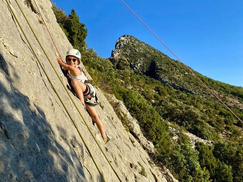 Une grimpeuse en herbe escalade une falaise école dans les gorges du Verdon