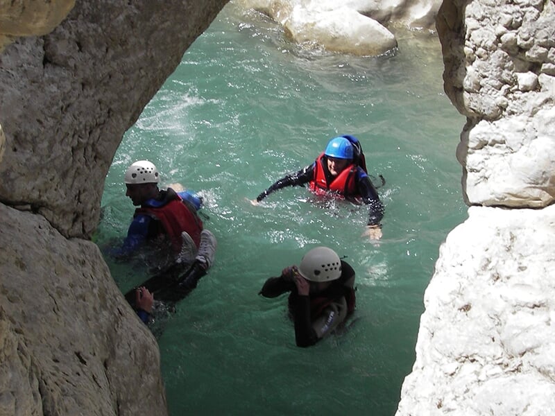 Les stagiaires d'une randonnée aquatique nagent dans le courant d'un cours d'eau.