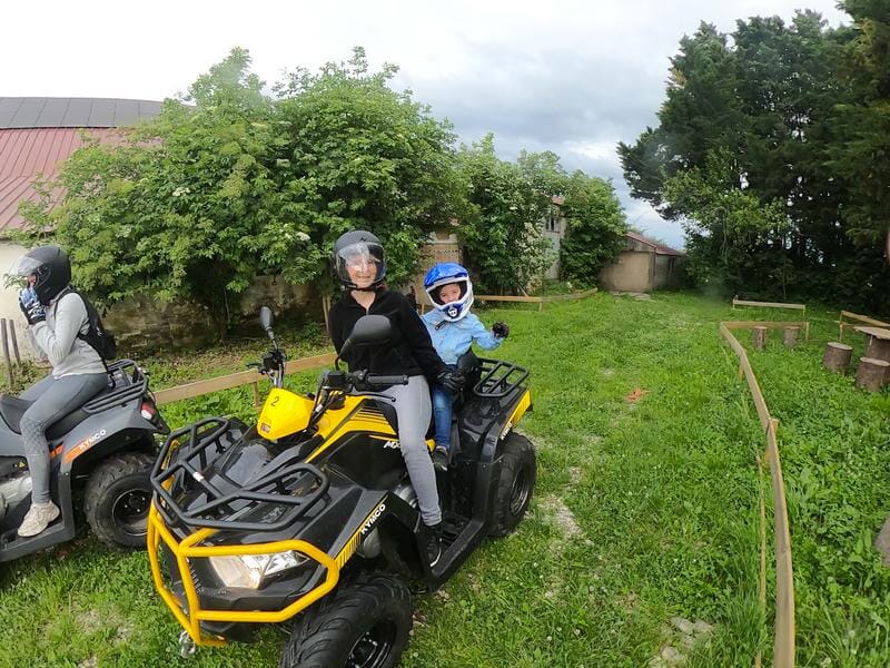 Une femme et un enfant sur un quad à l'arrêt sur un chemin de campagne