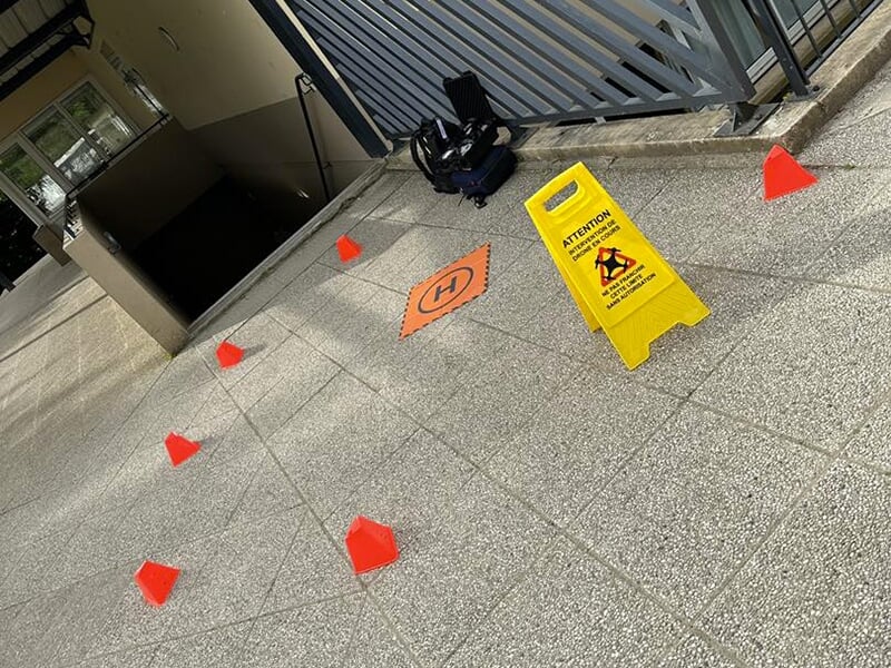 Plusieurs cônes orange et le panneau attention vol de drone délimitent une zone de vol autorisée