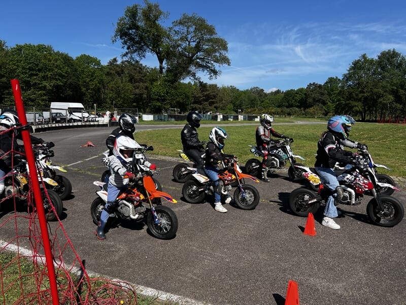 Groupe d'enfant participant à un cours de moto sur circuit