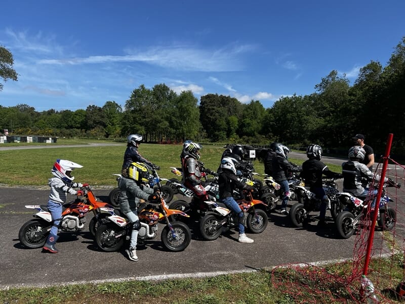 Groupe d'enfant participant à un cours de moto sur circuit