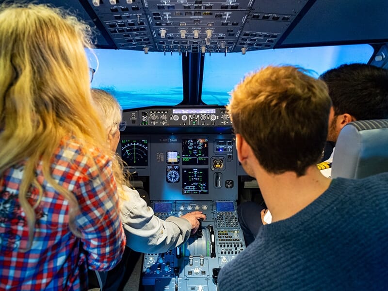 Un groupe de passionnés d'aviation assiste à un vol en simulateur à bord d'une réplique d'un cockpit d'A320