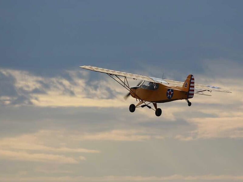 Un avion de tourisme de type Zlin Savage vole dans le ciel bleu au dessus de Saumur