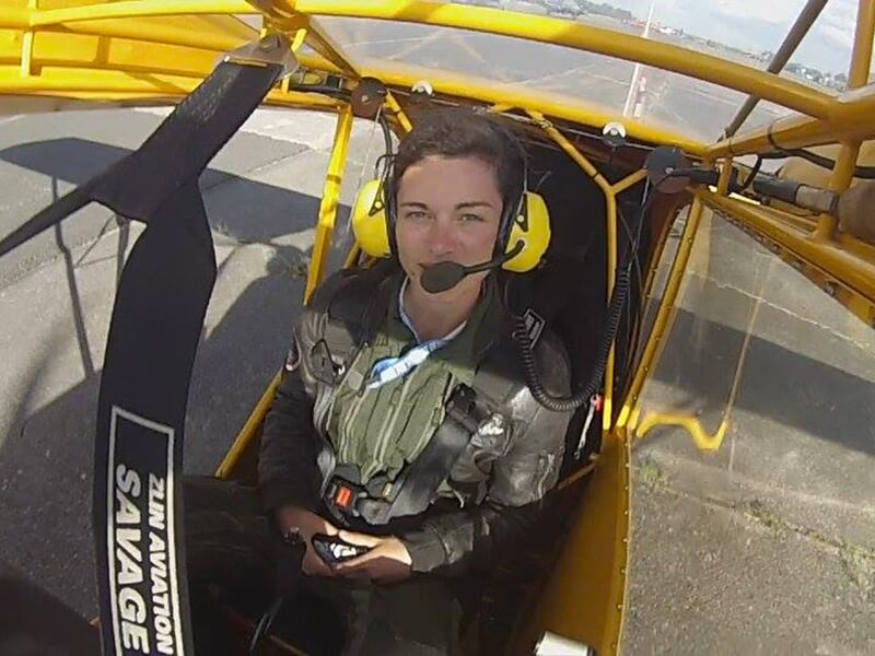 Une jeune femme portant un casque radio attend de faire son premier vol à bord d'un avion vintage à Saumur