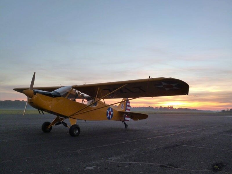 Un avion léger de type Zlin Savage sur la piste d'un aérodrome au crépuscule