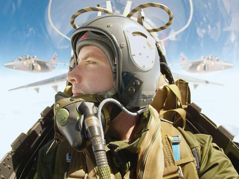 Un pilote de chasse dans le cockpit de son appareil avec deux autres chasseurs en arrière-plan