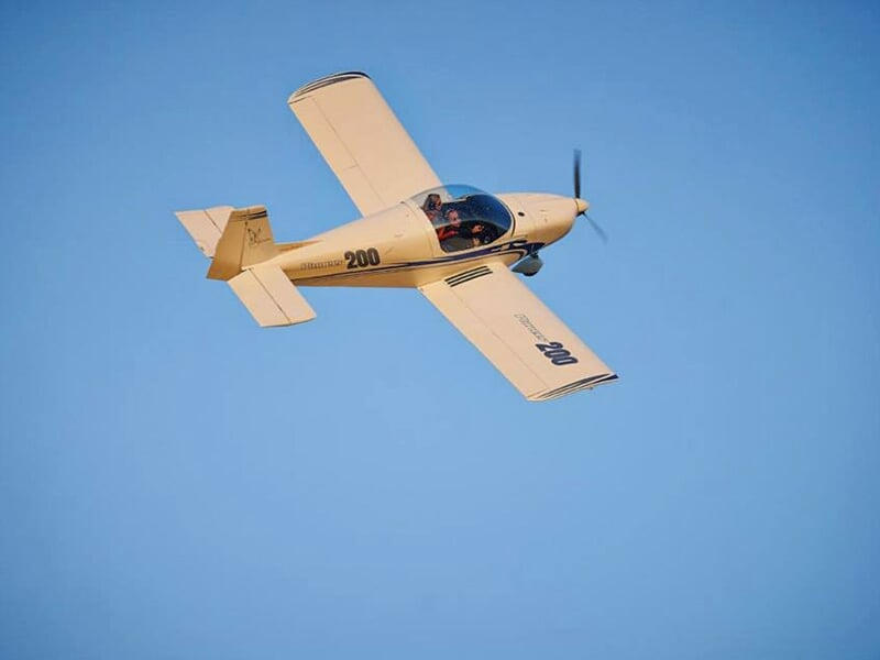 Un avion léger de type Pioneer 200 opère un virage dans le ciel bleu