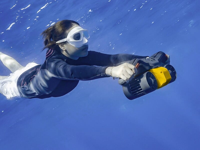 Une jeune touriste plonge avec un scooter sous-marin dans les eaux limpides de la mer Méditerranée.