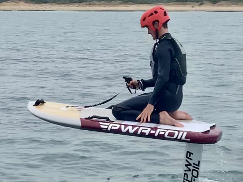 Un surfer pratique le foil électrique télécommande Bluetooth à la main