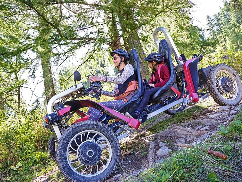 Un swincar négocie une descente sur un chemin forestier des Alpes du Sud