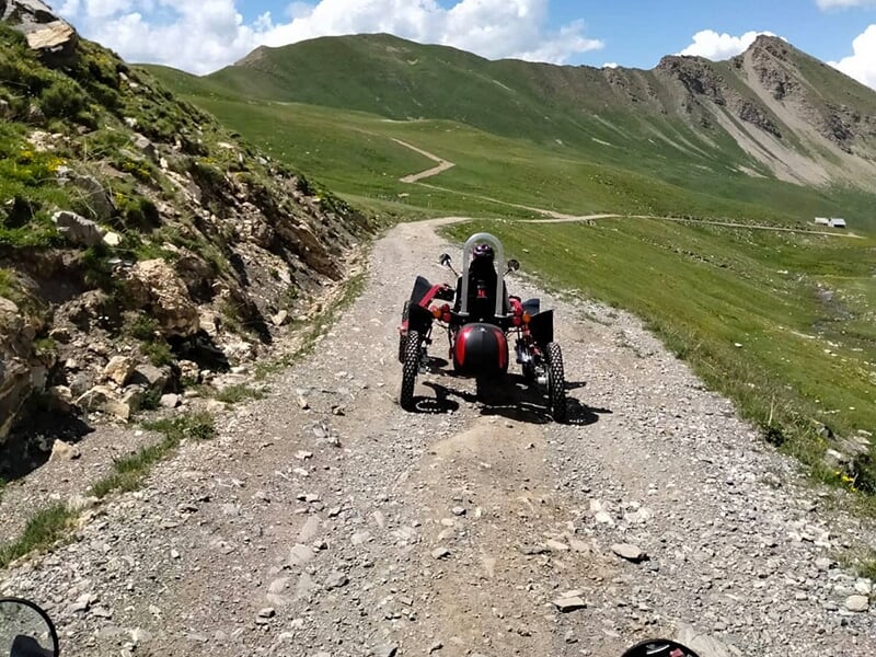 Un swincar roule sur un chemin de pierre en direction d'un sommet des Alpes du Sud