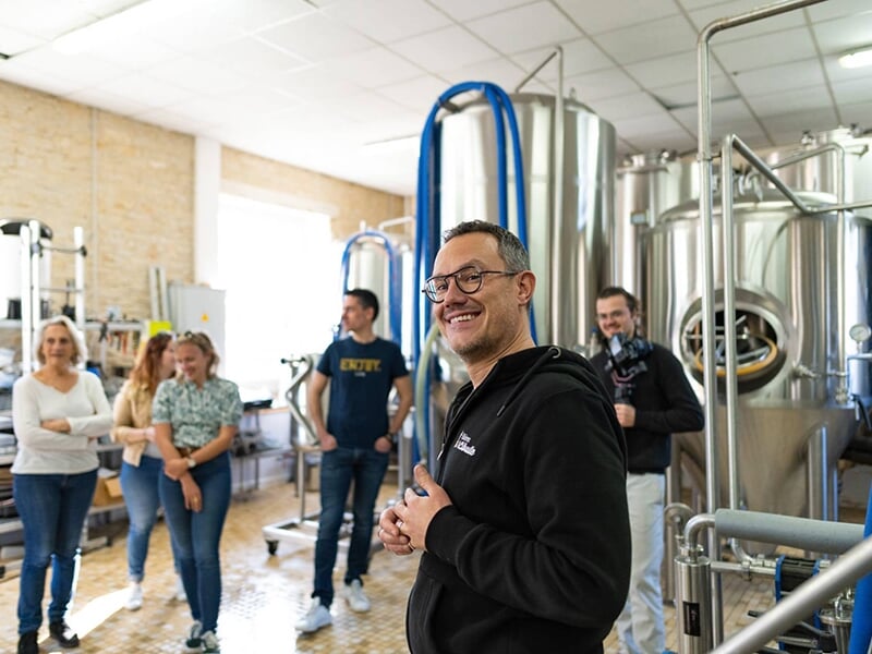 Un producteur de bière présente les installations de sa brasserie à des touristes dans le marais Poitevin
