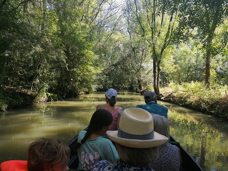 Un groupe de touristes fait une balade en barque sur un canal du marais Poitevin