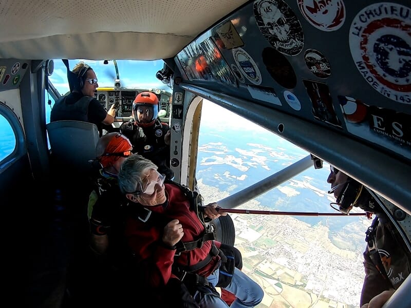 Personne âgée prête à sauter en parachute depuis un avion avec un instructeur à l'aéroport de Dijon Bourgogne.