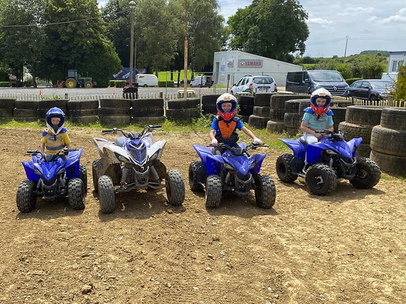 De jeunes pilotes à l'arrêt sur leur quad lors d'un stage de pilotage quand enfant