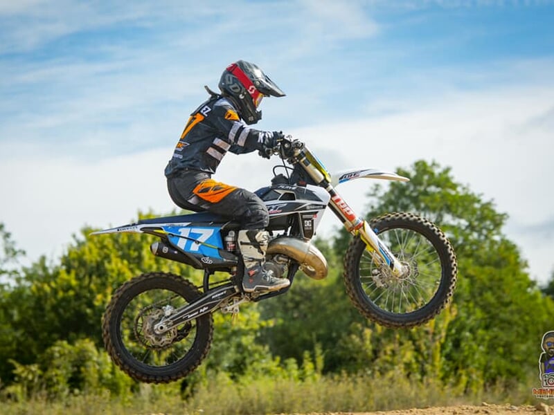 Un pilote de moto tout terrain casque sur la tête en plein au milieu d'un saut