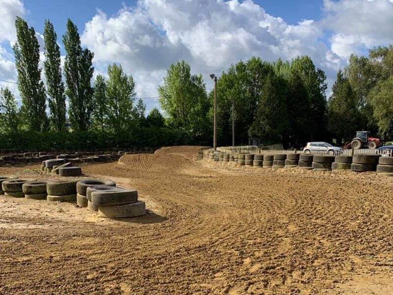 Le virage serré d'un terrain de motocross en terre entouré de pneus
