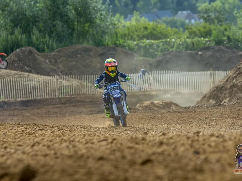 Un enfant pratique le motocross sur un terrain en terre