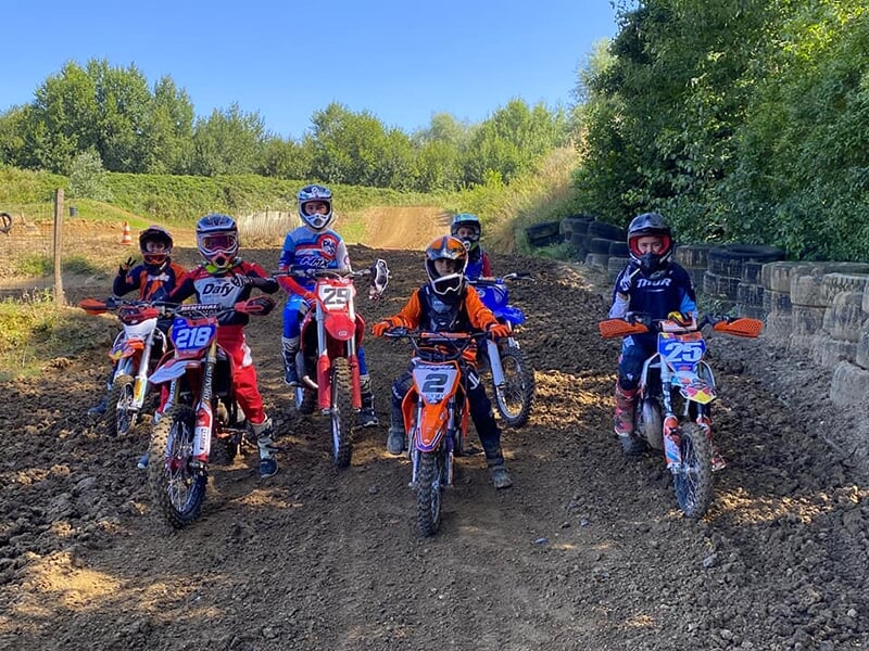 Des enfants pratiquent le motocross sur une piste boisée dans le Nord de la France