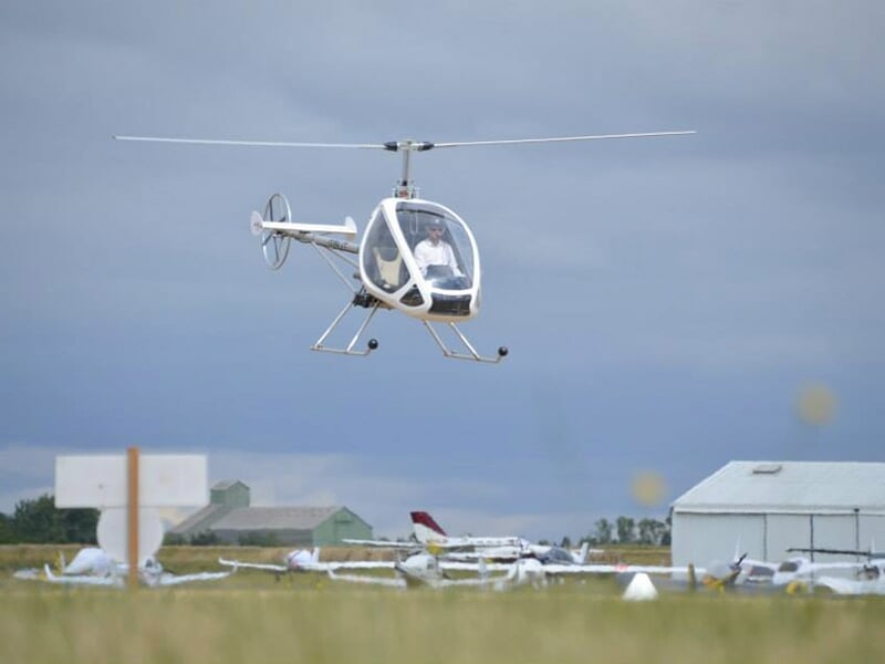 Un hélicoptère Dynali H3 en vol stationnaire au dessus d'un aérodrome