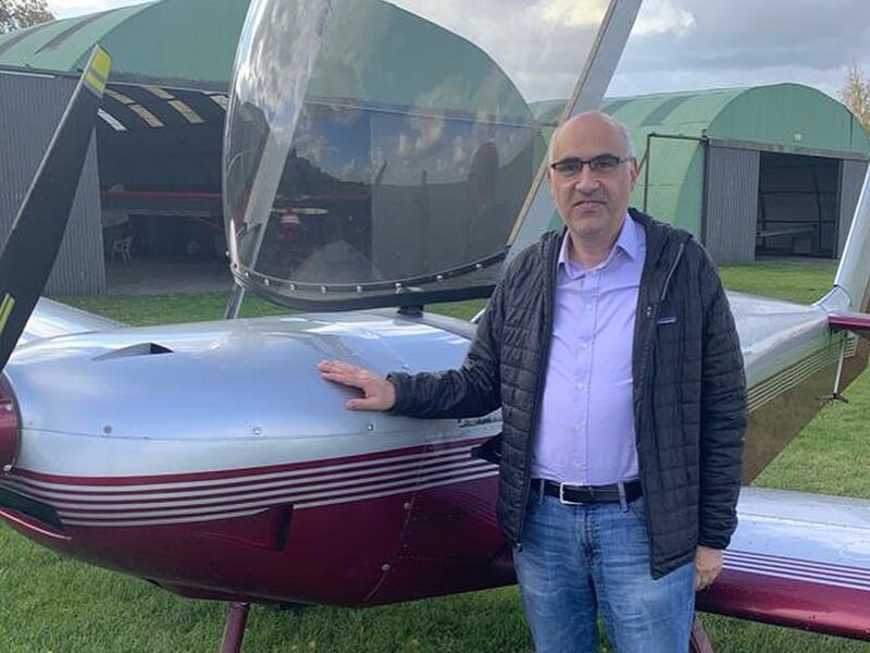 Un passionné d'aviation pose devant un avion Zenair avant son vol d'initiation