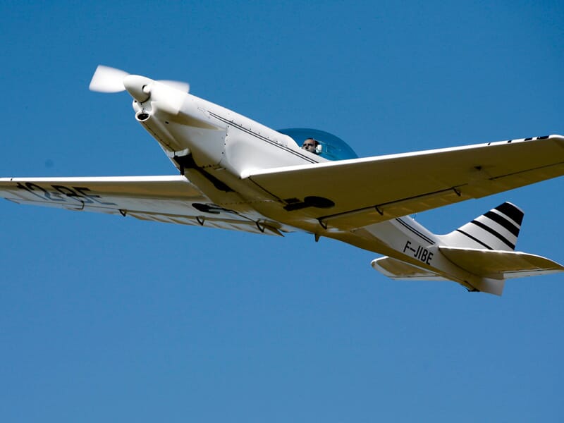 ULM multiaxe blanc lancé dans le ciel bleu