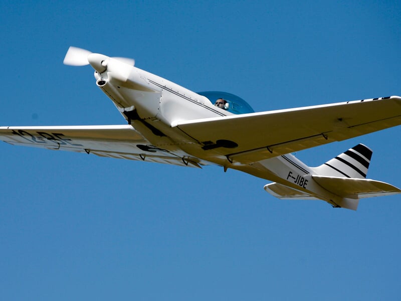 ULM multiaxe blanc lancé dans le ciel bleu
