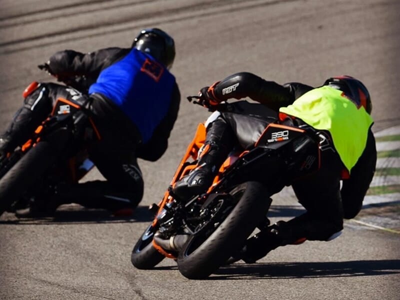 Deux motards travaillent ensemble leur coordination sur une piste de moto de compétition